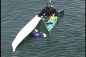 second swimmer does wet re-entry while kayak being held by the first paddler