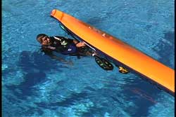 Slipping feet into overturned kayak