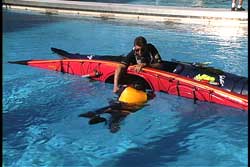 rescuer holding edged kayak and victim