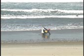 paddler adjust kayaks angle to the waves on shore