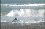 Incoming surge starts turning kayak on shore