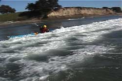 paddler in front of wave moving toward shore