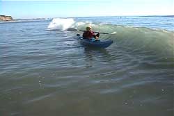 kayaker set up for wave that is curling up to break on them